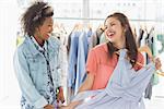 Two happy young women shopping in clothes store