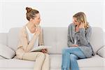 Upset woman talking to her therapist on the couch at therapy session