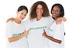 Attractive team of volunteers smiling at camera on white background