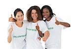Attractive team of volunteers giving thumbs up at camera on white background