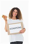 Happy volunteer holding a box of donations and jam jar on white background
