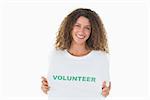 Smiling volunteer showing her tshirt to camera on white background