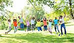 Group of excited multiethnic friends jumping in park