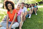 Portrait of confident multiethnic friends sitting in a line on campus