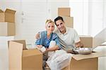 Portrait of a smiling couple unpacking boxes in a new house