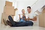 Portrait of a smiling couple with takeaway food and boxes in a new house