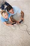 High angle view of a couple playing video games on area rug at home