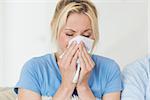 Closeup of a young woman suffering from cold with eyes closed