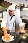 Portrait of a smiling male cook wiping the counter top in the kitchen