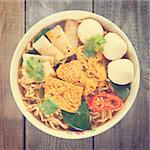 Spicy curry instant noodles soup in vintage revival retro style on wooden dining table.