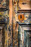 Detail of vintage key hole on weathered wooden door