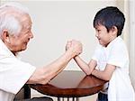 grandpa hand wrestling with grandson.