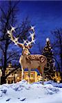 Christmas deer with illuminated star light horns in snowy town