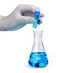 Gloved hand pours blue liquid laboratory test sample