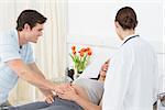 Female doctor with happy expectant couple in hospital ward