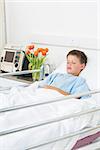 Sick little boy resting in hospital ward