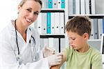 Little boy receiving an injection by female pediatrician in clinic