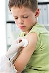 Little boy receiving vaccination in arm in clinic