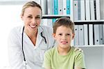 Portrait of friendly female doctor with boy in clinic