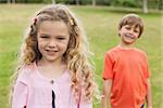 Portrait of two smiling kids standing at the park