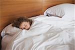 High angle view of a young girl sleeping in bed at home