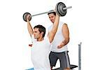 Male trainer helping young fit man to lift the barbell bench press over white background