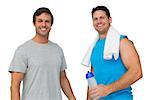 Portrait of two fit young men with water bottle and towel standing over white background
