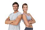 Portrait of a sporty young couple with arms crossed over white background