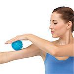Portrait of a young woman holding stress ball on arm over white  background