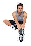 Portrait of a young man stretching hands to leg over white  background