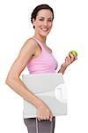 Side view portrait of a young woman with weight scale and apple over white background