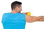 Rear view of a content young man holding stress ball over white  background
