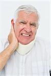 Close-up portrait of a senior man with cervical collar over white background