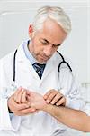 Male doctor taking a patients pulse at the medical office