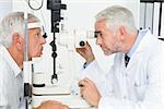Side view of an optometrist doing sight testing for senior patient