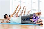 Full length of fitness class stretching legs and hands in row at yoga class