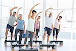 Portrait of fitness class stretching hands in yoga class