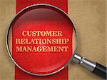 CRM - Customer Relationship Management Concept. Magnifying Glass on Old Paper with Red Vertical Line Background.