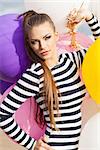 close-up of beautiful girl with smokey eye make up and long hair in black and white striped dress with bunch of multicolored balloons