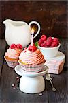Sweet cupcakes with fresh raspberry and birthday candle.