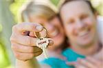 Happy Couple Holding House Key with Home Text On The Key.