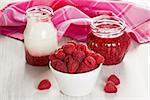 Raspberry, homemade yogurt and jam in white bowl