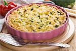 Quiche pie with broccoli, chicken and ham on wooden background