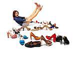 Studio shot of young woman and huge selection of women's shoes. Copy space.