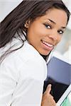 Beautiful happy young African American woman or girl smiling and using a tablet computer