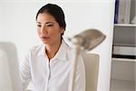 Casual businesswoman working at her desk in her office