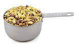 Chopped pistachio nuts presented in an American metal cup measure, isolated on a white background