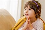 Young girl sitting on sofa daydreaming