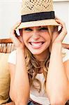 Young woman putting on straw hat