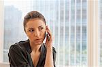 Unhappy businesswoman using cellphone in office
